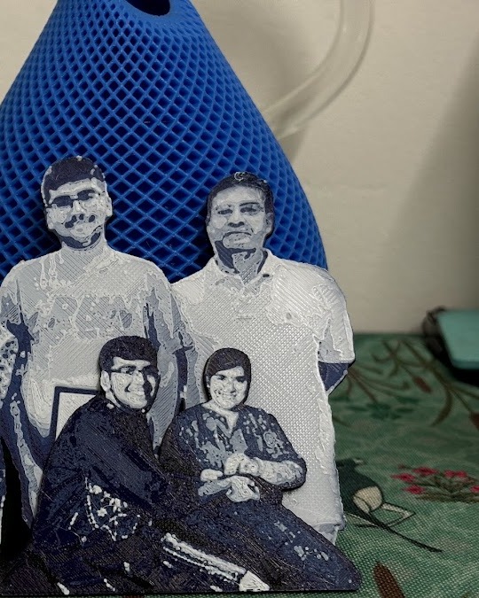 3D-printed family plaque of four people standing on a table.