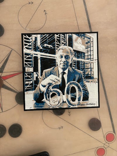 Cool-grey 3D-printed plaque of a man in a suit with the number 60, resting on a desk.